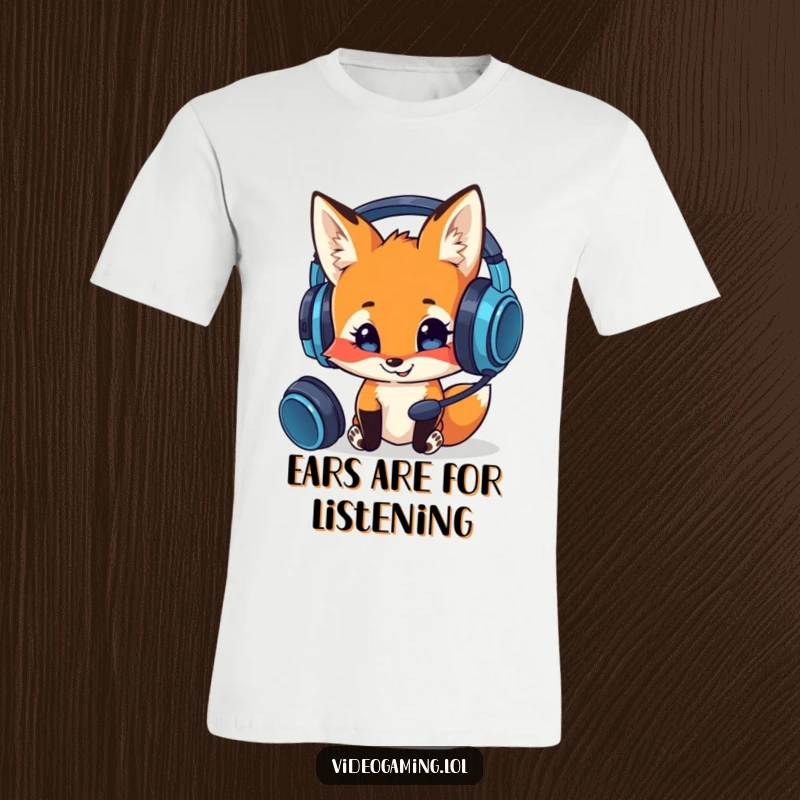 Funny t-shirt with a curious fox smiling and inspecting a complex gaming headset, representing gamer tech appreciation humorously.
